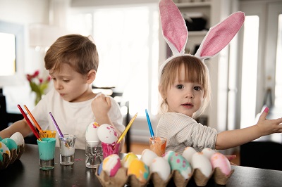 Kids decorating hard-boiled eggs with colourful paints