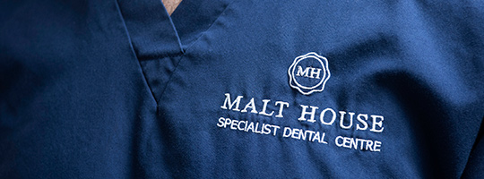 Embroidery on dental uniform showing logo and name of Malt House Specialist Dental Centre