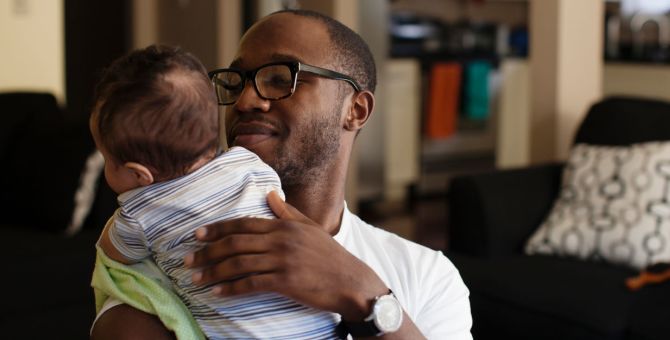 A dad having a cuddle with his baby