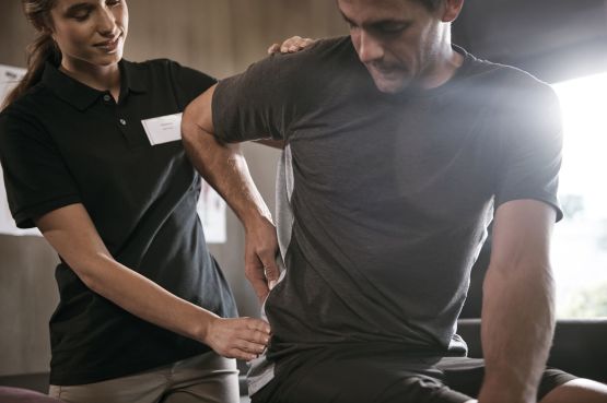 physiotherapist helping a patient with lower back pain