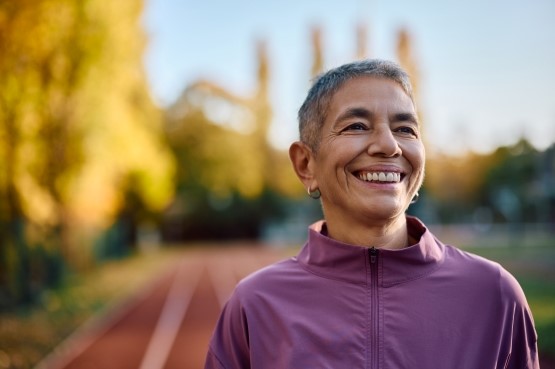 woman smiling whilst taking a break from running