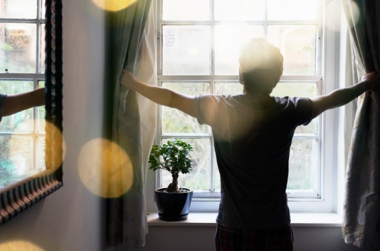 person letting sun in the room