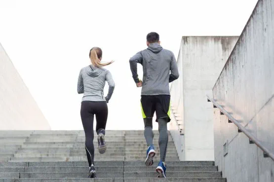 Two people running up some stairs