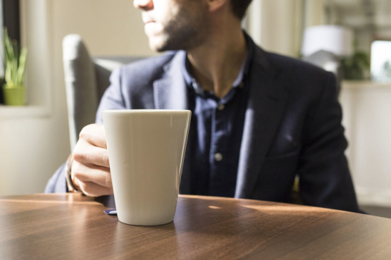 Image of man drinking tea and looking out of the window