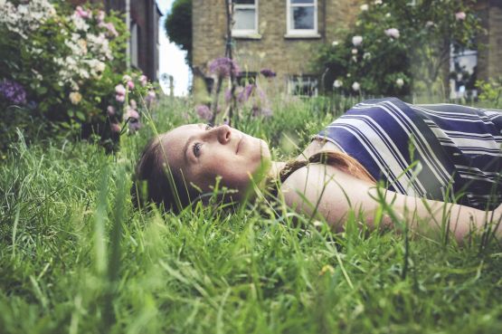 A girl lying down in grass
