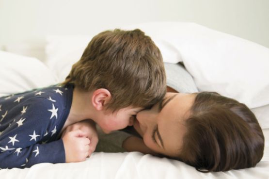 A mother and her young son laying on a bed