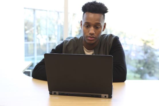 A teenage boy is on laptop