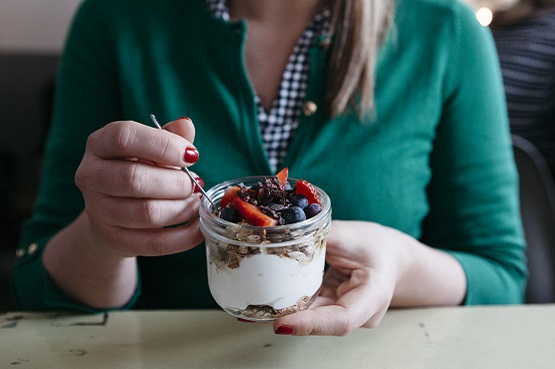 Woman holding a yogurt pot