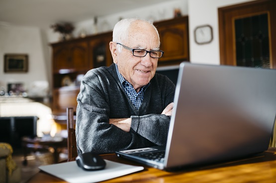 An older man sat at a laptop