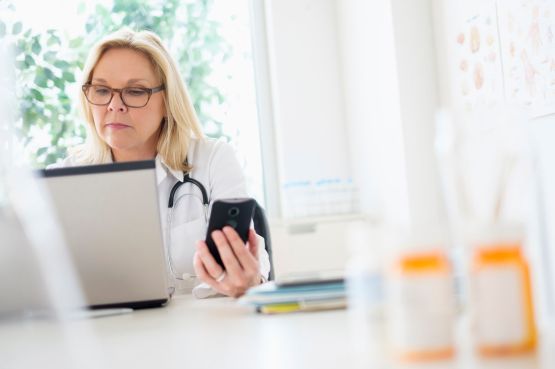 female doctor on phone and laptop