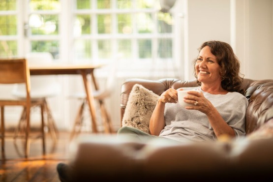 A woman relaxing with a cup of coffee on a sofa