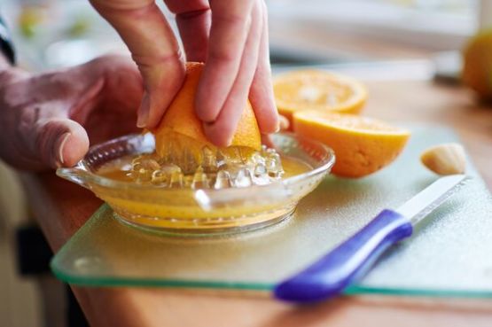 person juicing an orange