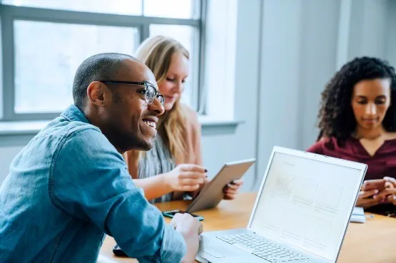 A picture of three people in a meeting