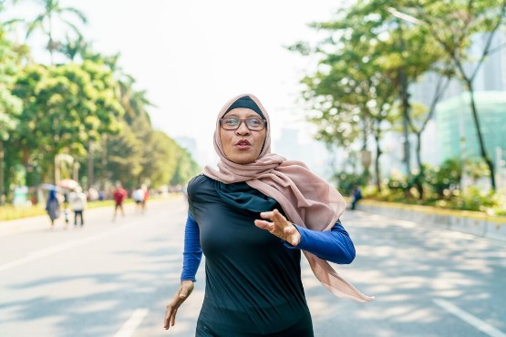 woman running in the park wearing headscarf