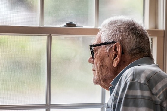 an older man looking through a window