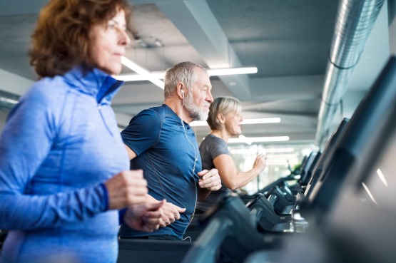 People exercising on a row of treadmills