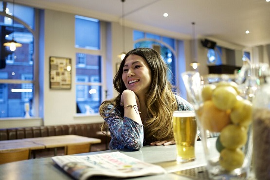 Photo of a woman drinking alcohol in a bar