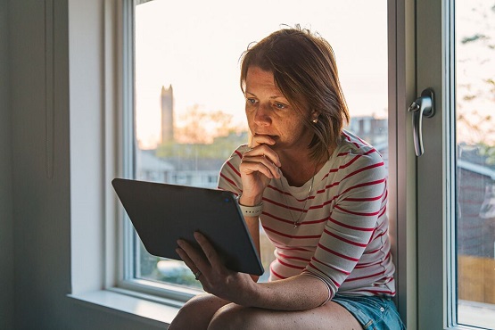 Woman watching tablet anxiously