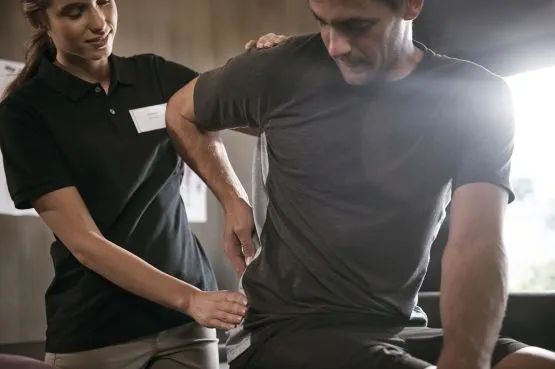 physiotherapist helping a patient with lower back pain