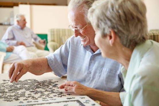two people in a care home completing a puzzle