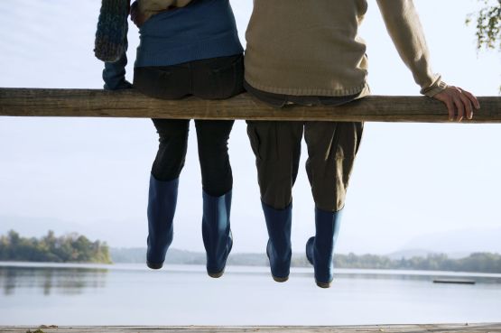 couple sitting on a branch by a lake