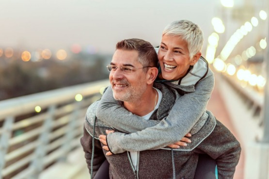 two people having fun, piggy back on a bridge