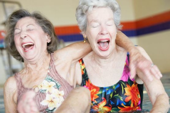 two older women having a laugh in the pool