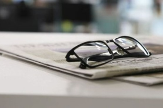 eye glasses and newspaper on a table