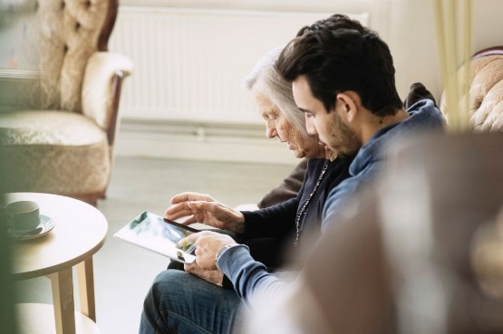 an older and younger person looking at photos