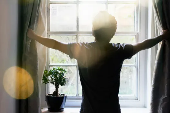 person opening curtains and stretching standing near the window