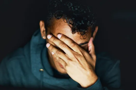 person rubbing their eyes looking worried