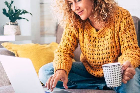 person sitting on a sofa and browsing on a laptop