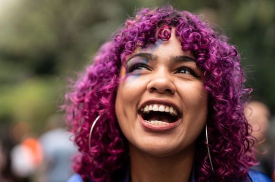 person smiling at a pride parade