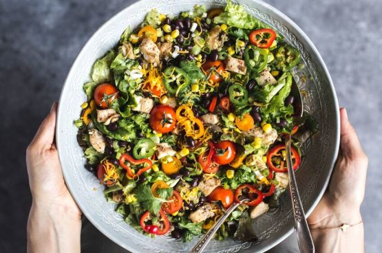 hands holding a salad bowl
