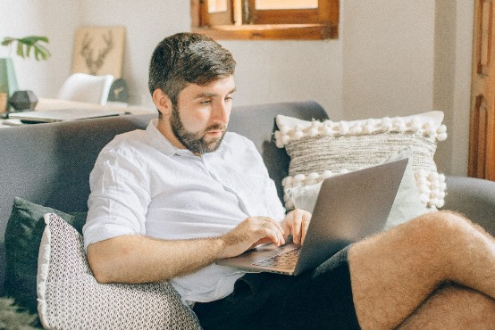 person sitting on a sofa with laptop in hand