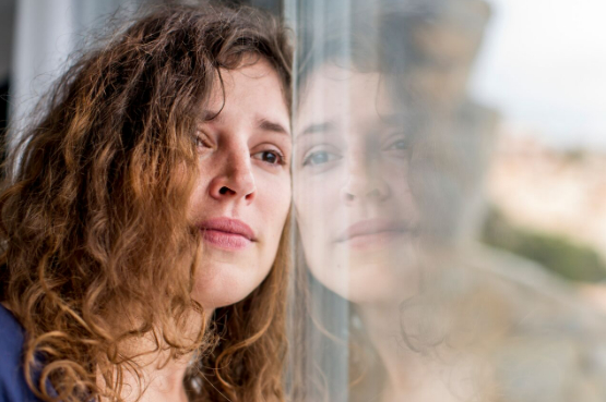worried person looking out window