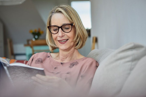 person with a pink top reading indoors