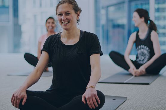 group of people practising yoga on a mat