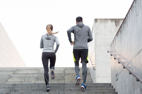 Two people running up some stairs