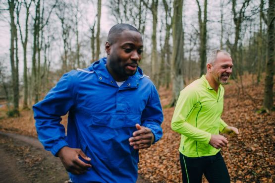 two people running in the woods