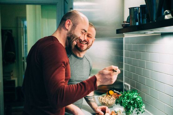 two people cooking at home, laughing