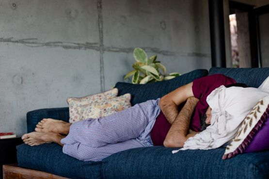 person sleeping on a blue sofa