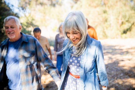 group of people smiling and walking outdoors