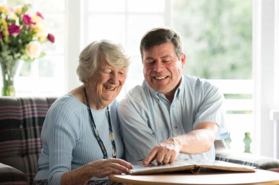 two seniors in a care home looking at photographs