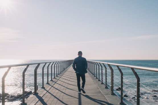 person walking alone on a pier