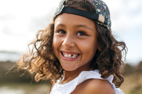 child with a missing tooth and a big smile
