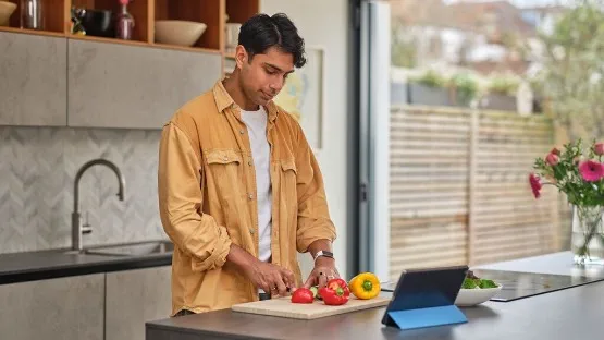 man cooking a recipe using ipad