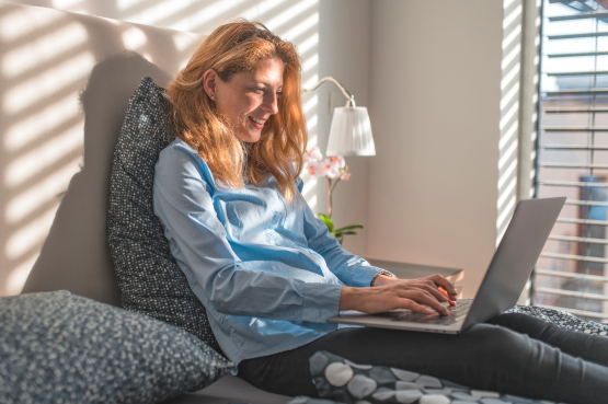 person using laptop on bed