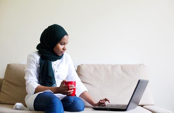 women sat looking at laptop