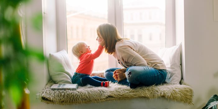 An image of a baby and mother sat in a window seat